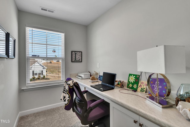 carpeted office space featuring built in study area, visible vents, and baseboards