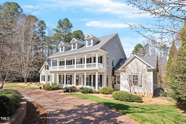 view of front of home featuring a balcony, crawl space, a porch, and a front yard