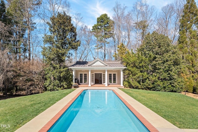 back of house featuring an outdoor pool, a lawn, metal roof, a standing seam roof, and french doors