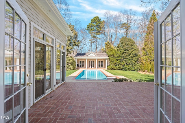 pool featuring a patio, a lawn, an outdoor structure, and an exterior structure