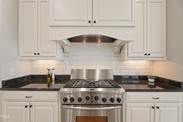 kitchen with white cabinets, premium range hood, backsplash, and high end stainless steel range