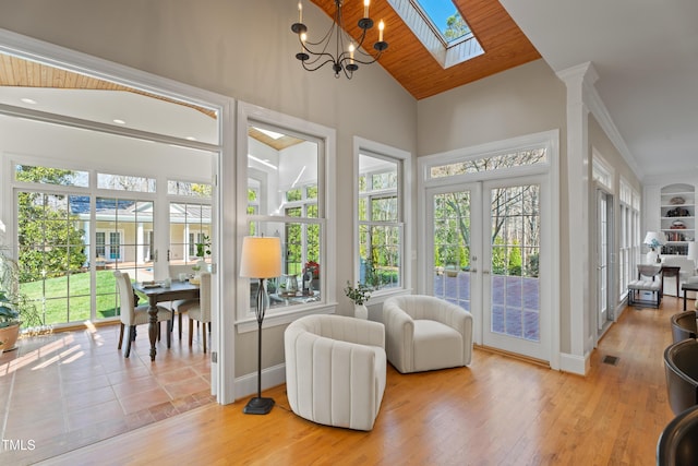 sunroom with wooden ceiling, lofted ceiling with skylight, visible vents, and french doors