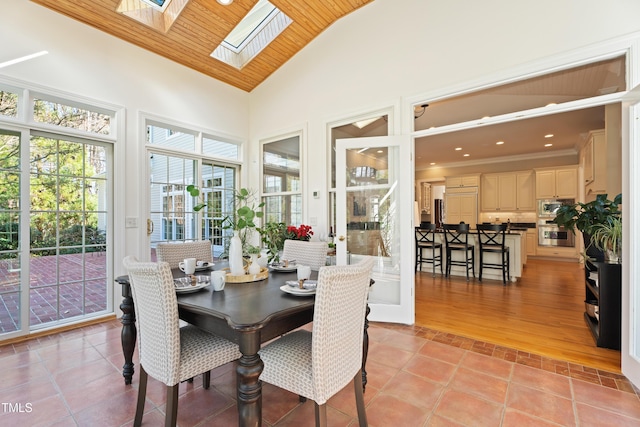 sunroom featuring vaulted ceiling with skylight and wood ceiling