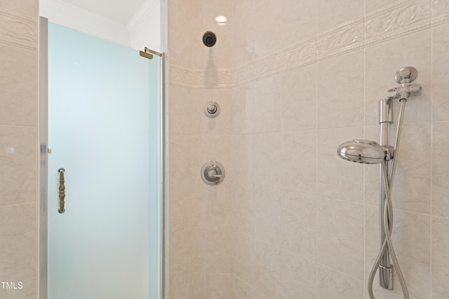 bathroom featuring a tile shower and crown molding