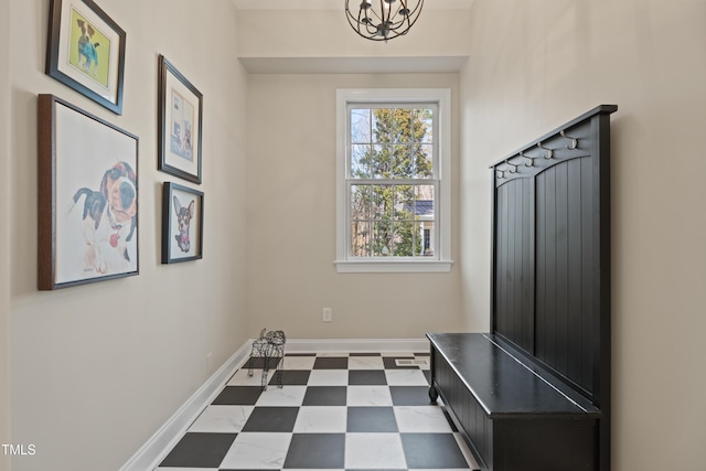 mudroom with a chandelier, dark floors, and baseboards