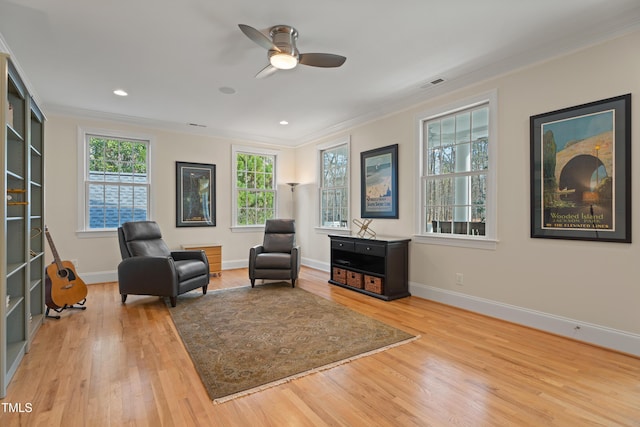 sitting room featuring ornamental molding, visible vents, baseboards, and wood finished floors