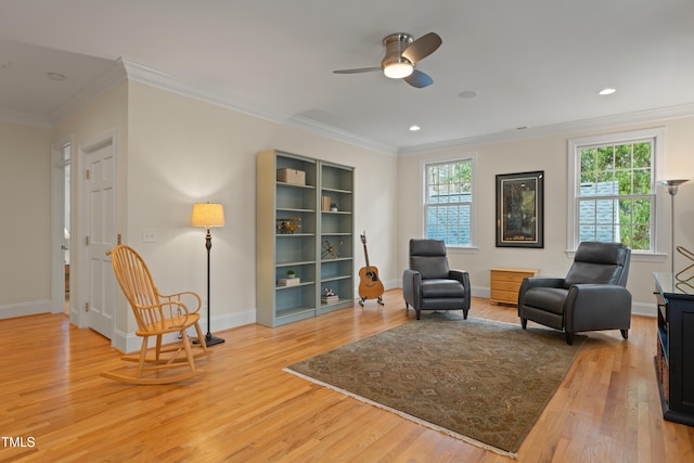 sitting room with light wood finished floors, ornamental molding, and a wealth of natural light