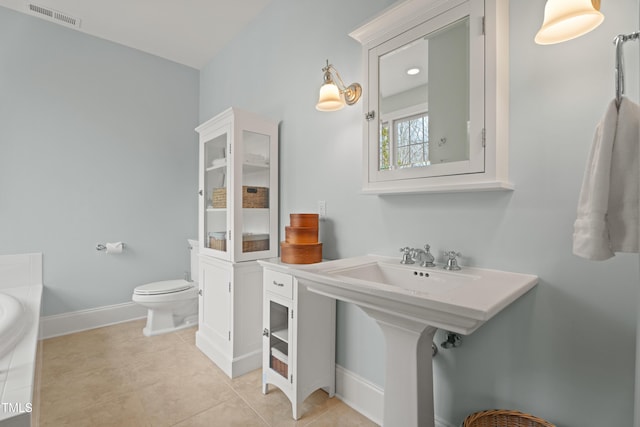 bathroom featuring toilet, tile patterned floors, visible vents, and baseboards