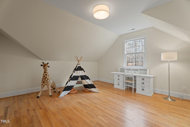 rec room featuring vaulted ceiling, light wood finished floors, visible vents, and baseboards