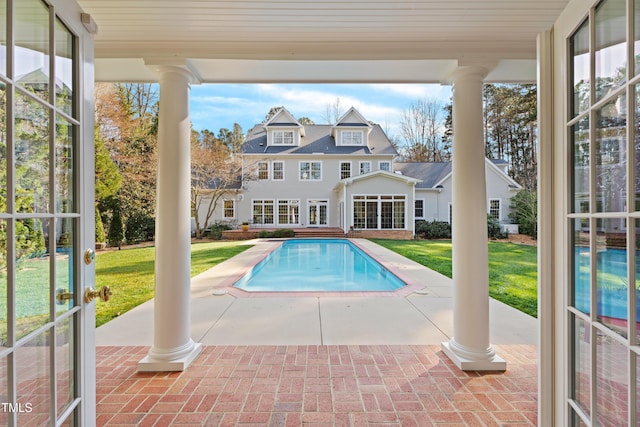 outdoor pool with a lawn and a patio area