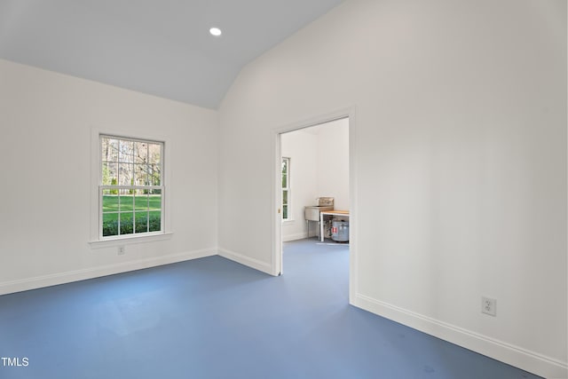 spare room with baseboards, recessed lighting, lofted ceiling, and finished concrete floors