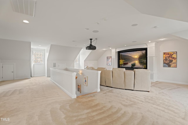 home theater featuring light carpet, vaulted ceiling, visible vents, and baseboards