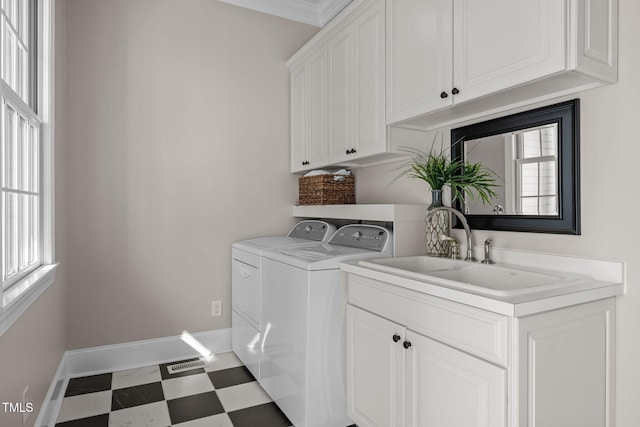 washroom with cabinet space, baseboards, tile patterned floors, washer and dryer, and a sink