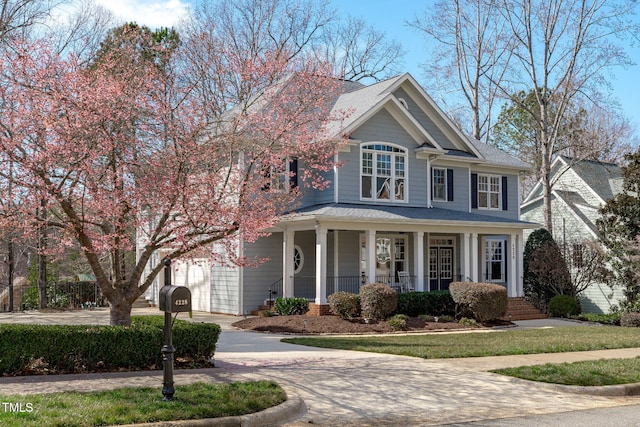 view of front of home with a porch, concrete driveway, and a garage