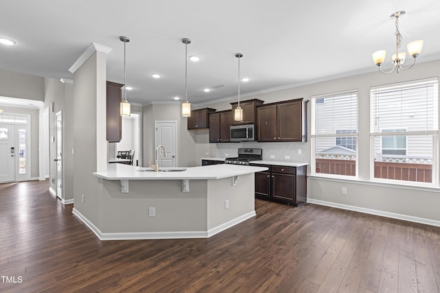 kitchen featuring stainless steel appliances, an inviting chandelier, light countertops, dark brown cabinets, and dark wood-style flooring