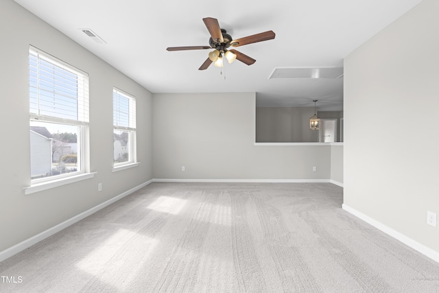 empty room featuring visible vents, baseboards, carpet floors, attic access, and ceiling fan