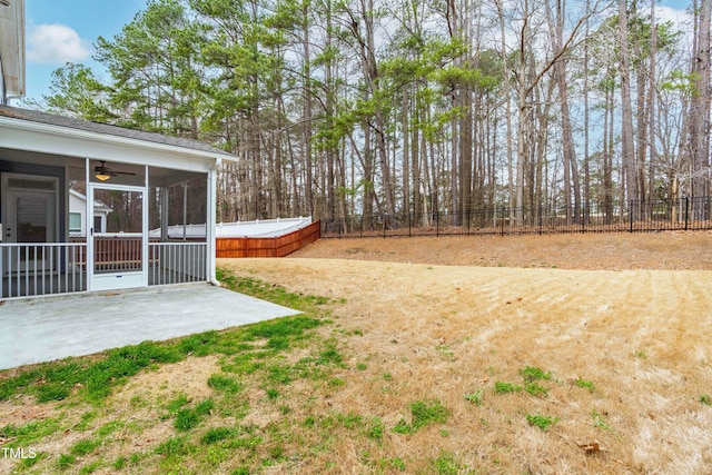 view of yard with ceiling fan, a patio, a fenced backyard, and a sunroom