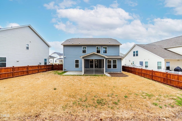 back of property featuring a fenced backyard, a patio area, a yard, and a sunroom