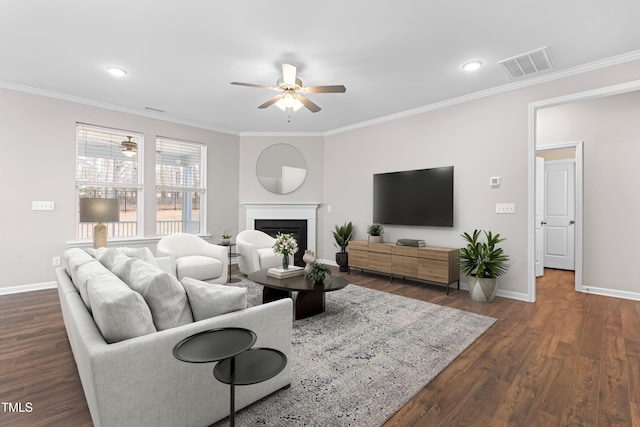 living area featuring visible vents, dark wood-type flooring, ornamental molding, baseboards, and ceiling fan