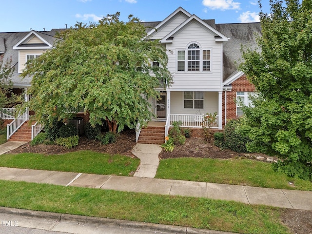 view of front of house featuring a porch, stairway, and a shingled roof