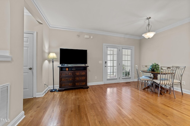 interior space with visible vents, ornamental molding, hardwood / wood-style flooring, and baseboards