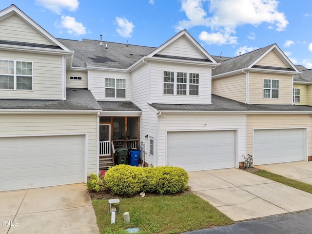 townhome / multi-family property featuring a garage, concrete driveway, and a shingled roof