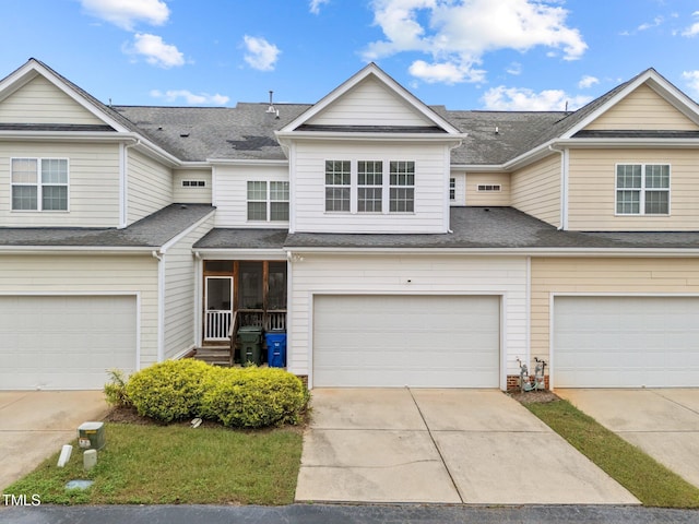 multi unit property featuring a shingled roof, driveway, and an attached garage