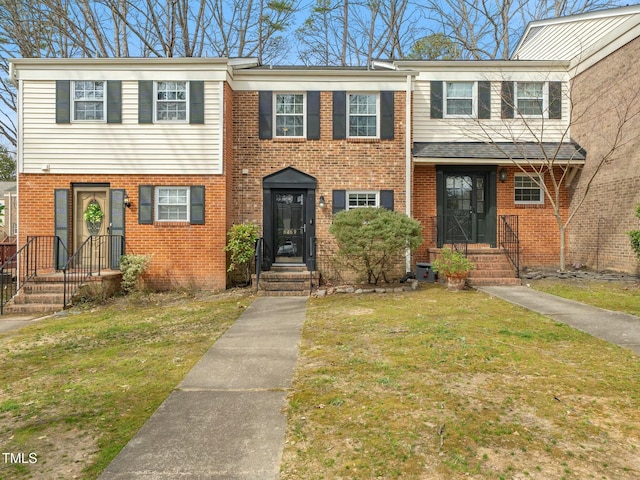 view of front of house featuring brick siding and a front lawn