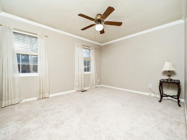 empty room featuring baseboards, crown molding, and light colored carpet