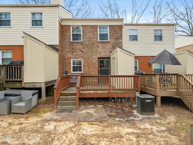 back of house with a chimney, brick siding, a deck, and central AC unit