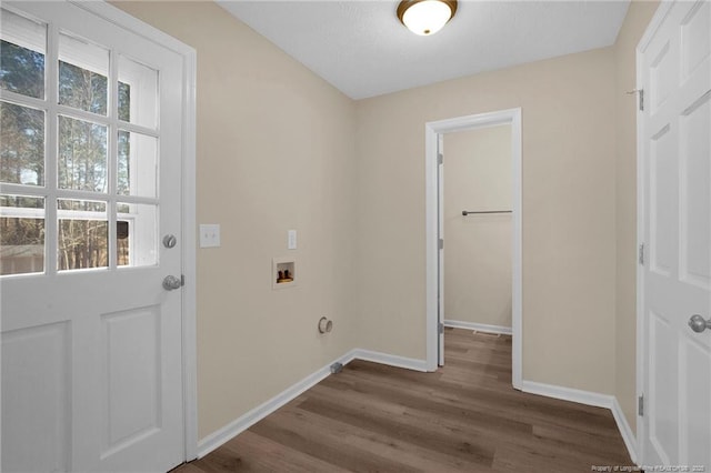 laundry area with laundry area, washer hookup, dark wood finished floors, and baseboards