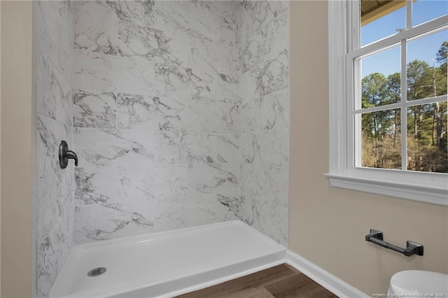 full bath with toilet, a shower stall, baseboards, and wood finished floors