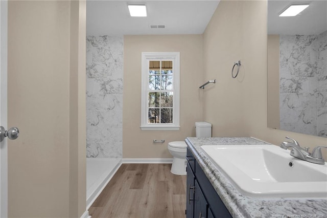 full bath featuring visible vents, toilet, wood finished floors, walk in shower, and vanity