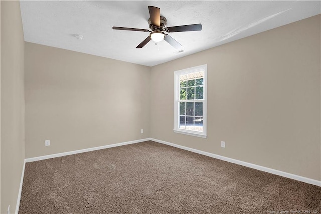 carpeted empty room with ceiling fan and baseboards