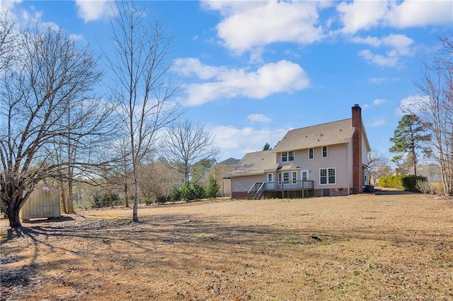 rear view of property with a chimney and a wooden deck