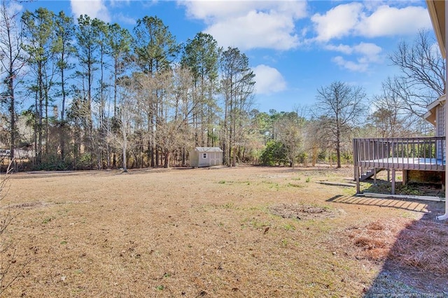 view of yard featuring an outbuilding, a storage unit, and a deck