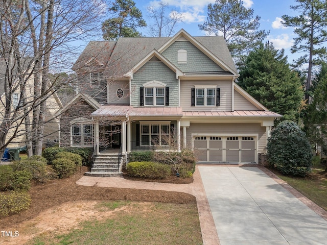 craftsman inspired home with a porch, a garage, and driveway