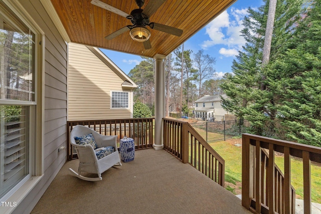 wooden terrace featuring a lawn, ceiling fan, and fence