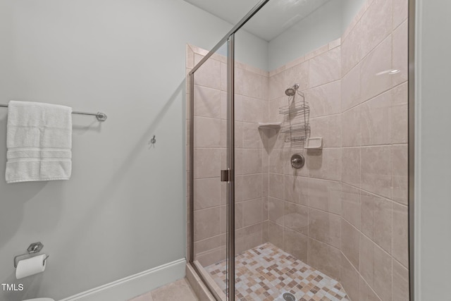 bathroom featuring a stall shower and baseboards