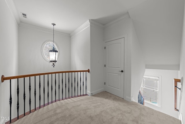 hall featuring an upstairs landing, carpet flooring, and crown molding