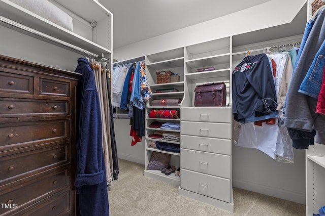 walk in closet featuring light colored carpet