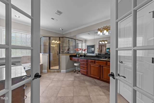 bathroom featuring a wealth of natural light, visible vents, a shower stall, and ornamental molding