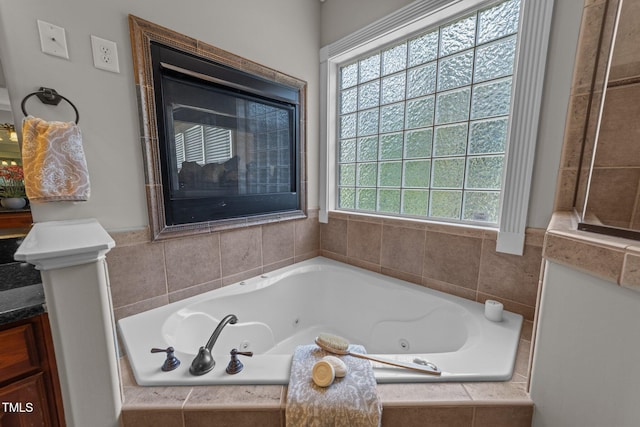 bathroom with a healthy amount of sunlight and a whirlpool tub