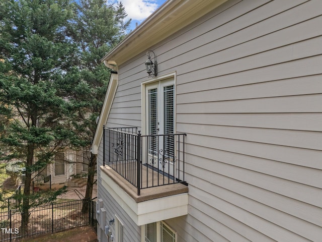 view of property exterior featuring a balcony and fence