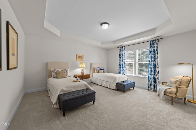 carpeted bedroom with a tray ceiling, visible vents, and baseboards