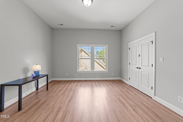 spare room with visible vents, baseboards, and light wood finished floors