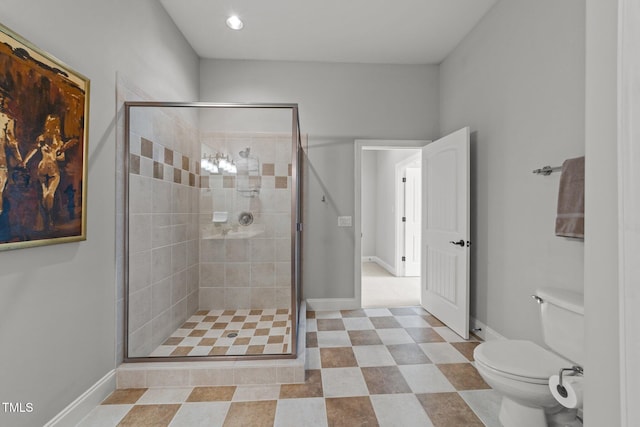 bathroom featuring baseboards, toilet, and a stall shower