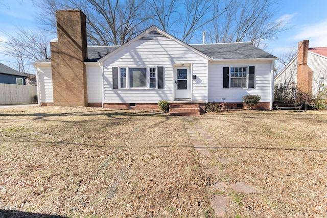 view of front of property with crawl space, fence, a chimney, and a front lawn