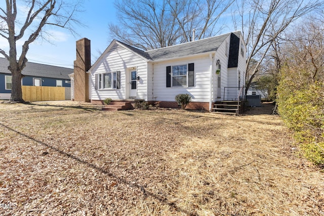 view of front of house featuring central AC, a chimney, and fence