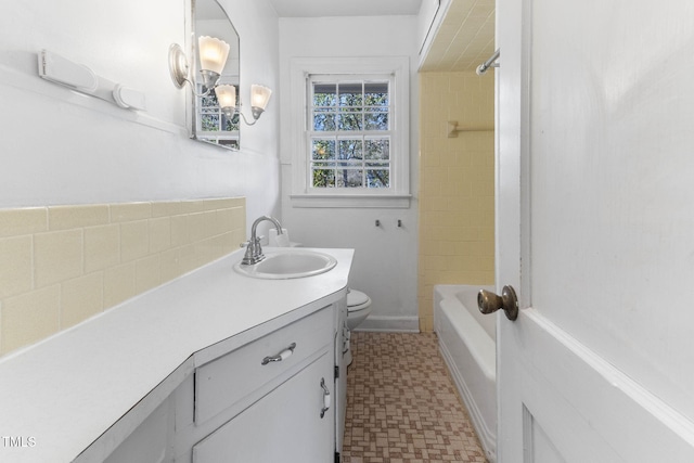 bathroom with shower / bathing tub combination, toilet, vanity, baseboards, and tile patterned floors